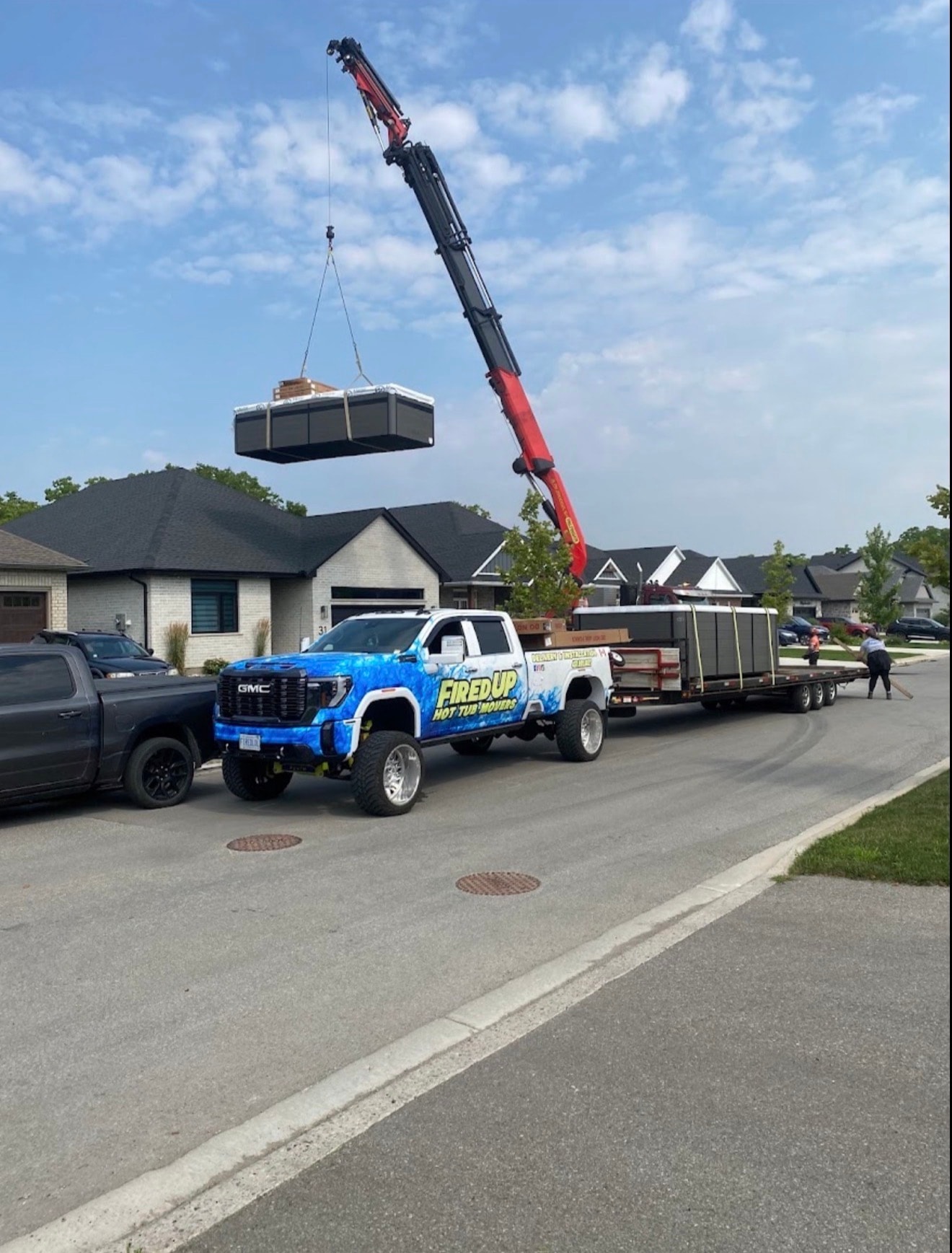Fired Up GMC truck with crane lifting hot tub